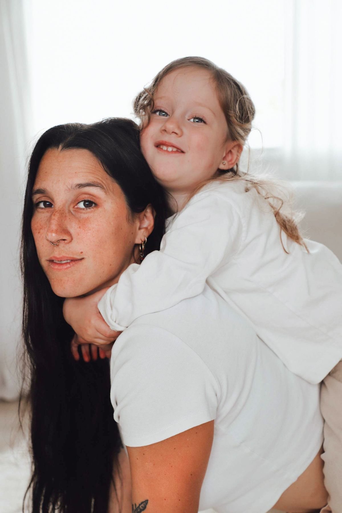 Agus, fotógrafa de Somos Nido, con su hija en la espalda