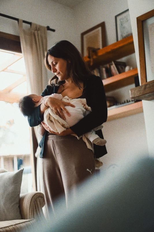 Mamá con su bebé en brazos en la cocina